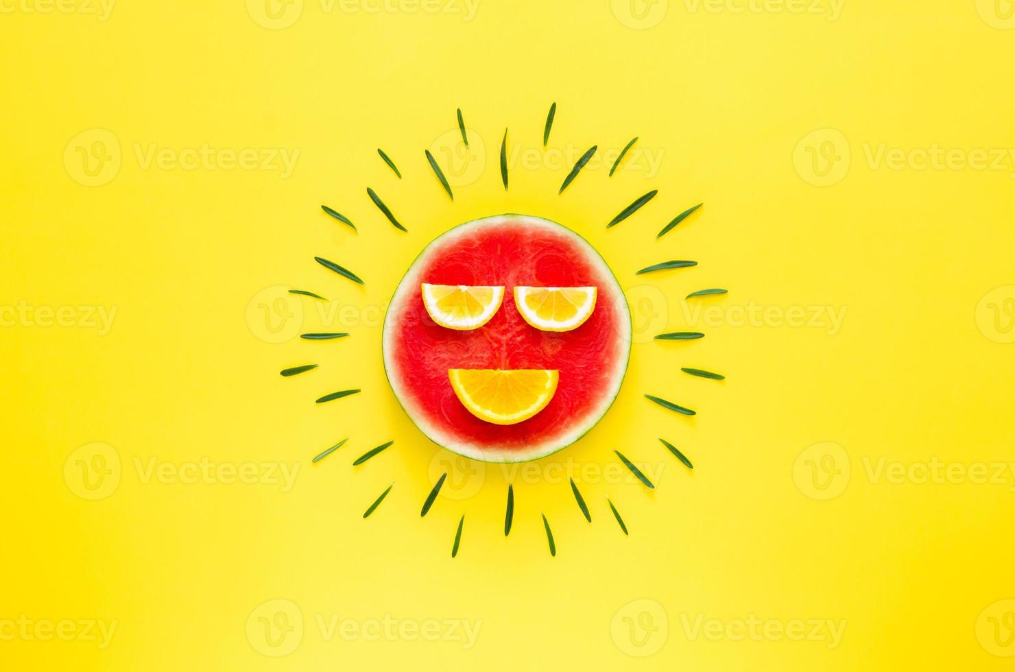 Red color smiling sun that made from watermelon, lemon and orange with rosemary leaves photo