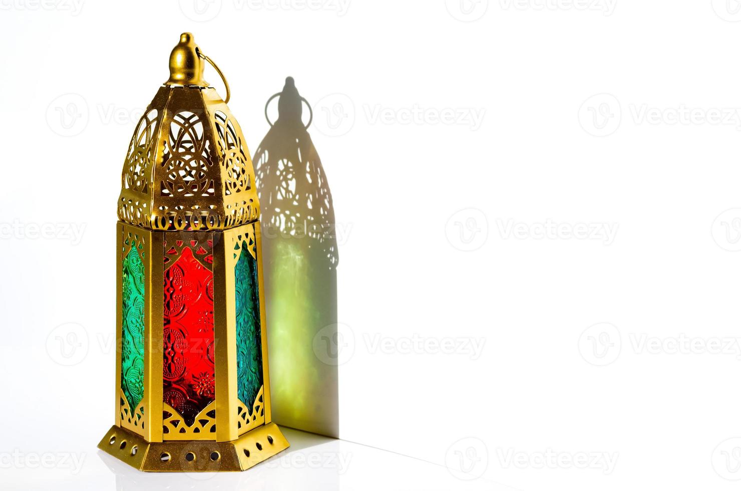 Golden lantern with shadow from sun light on white background. photo