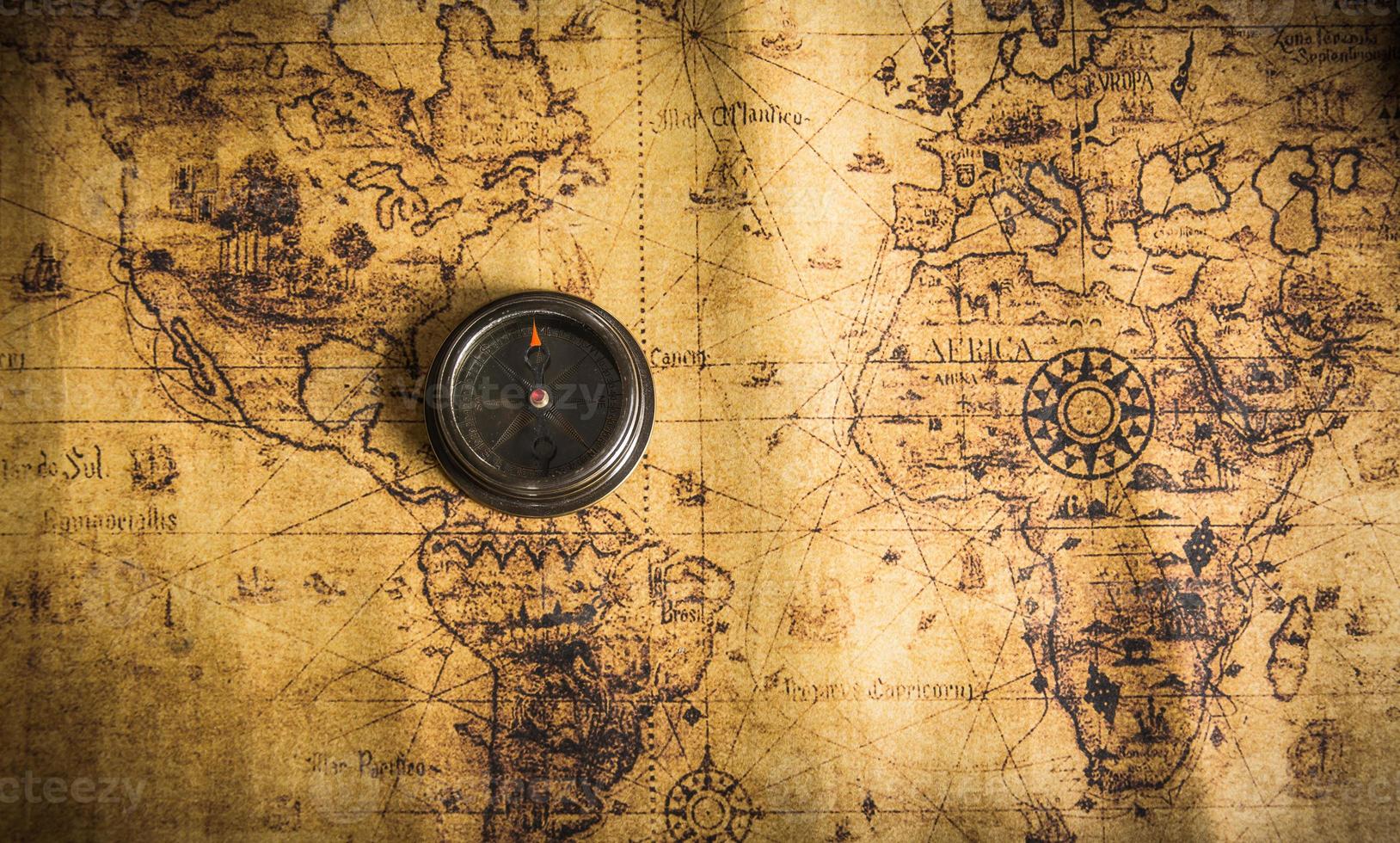 Old vintage retro compass on ancient map.The map used for background is in Public domain. photo