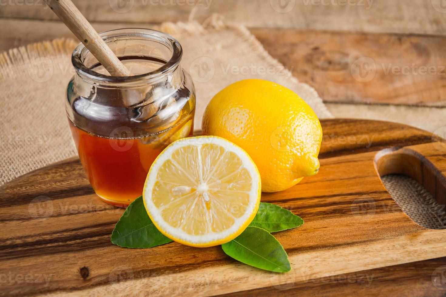 Honey with lemon on wooden table . Healthy nutrition photo