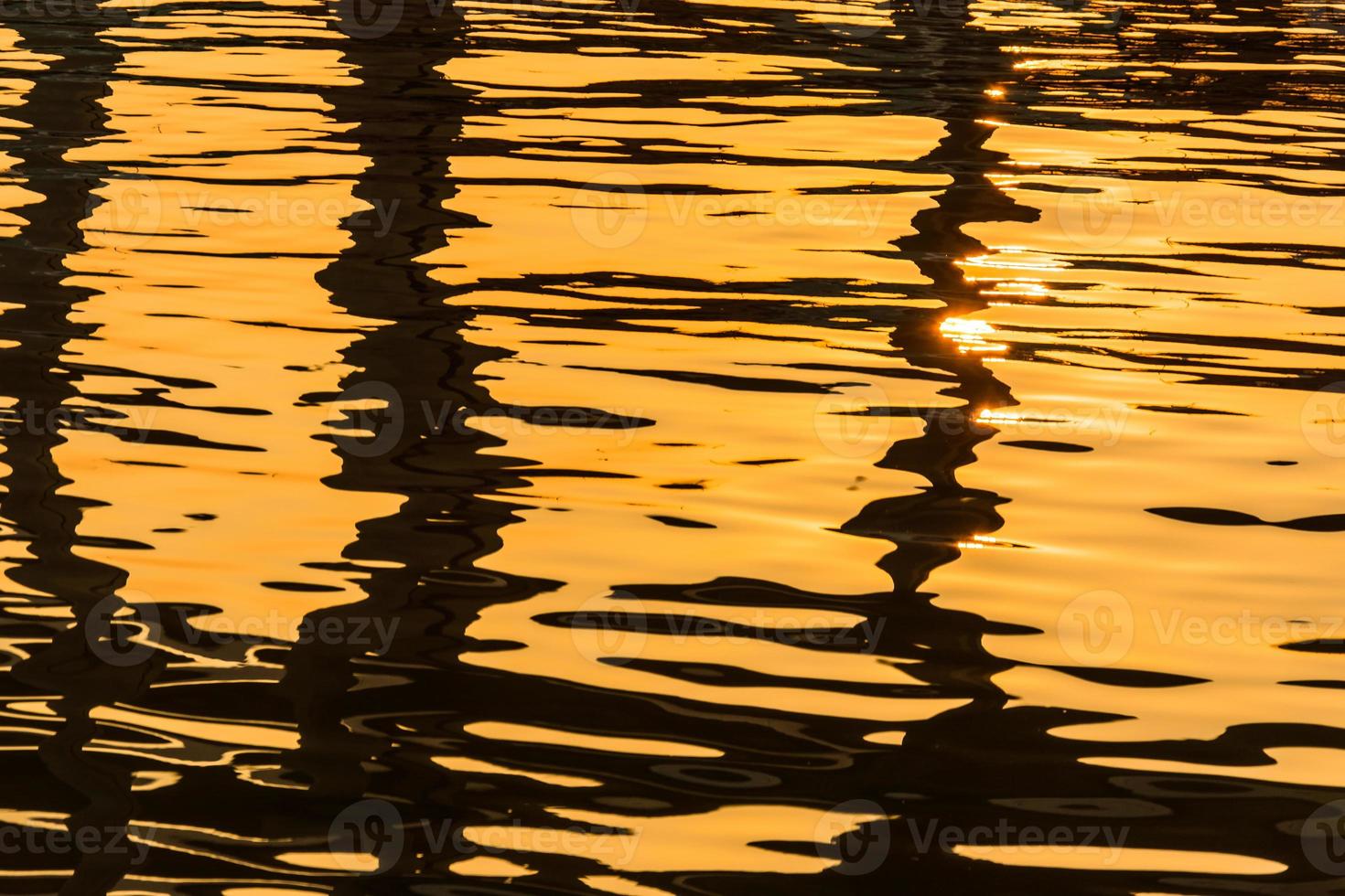 superficie del agua con reflejos de luz brillantes foto