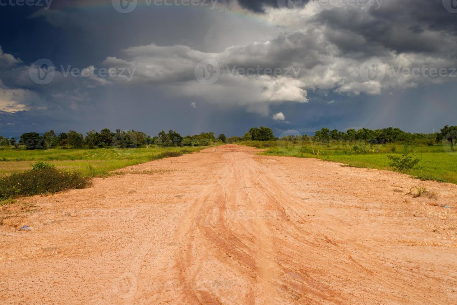 dirt road, cloudy sky and field photo