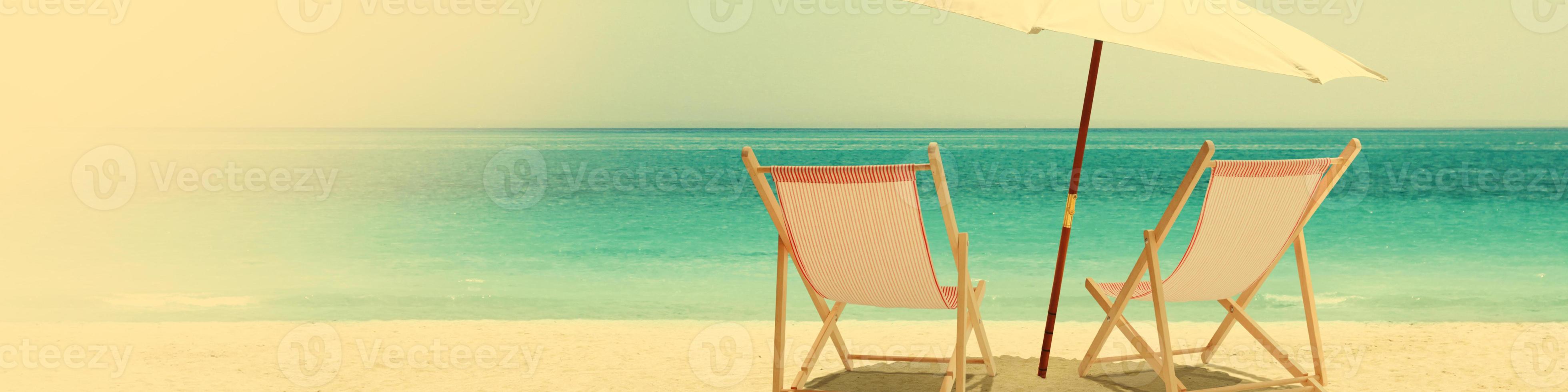 Relax on tropical beach in the sun on deck chairs. photo