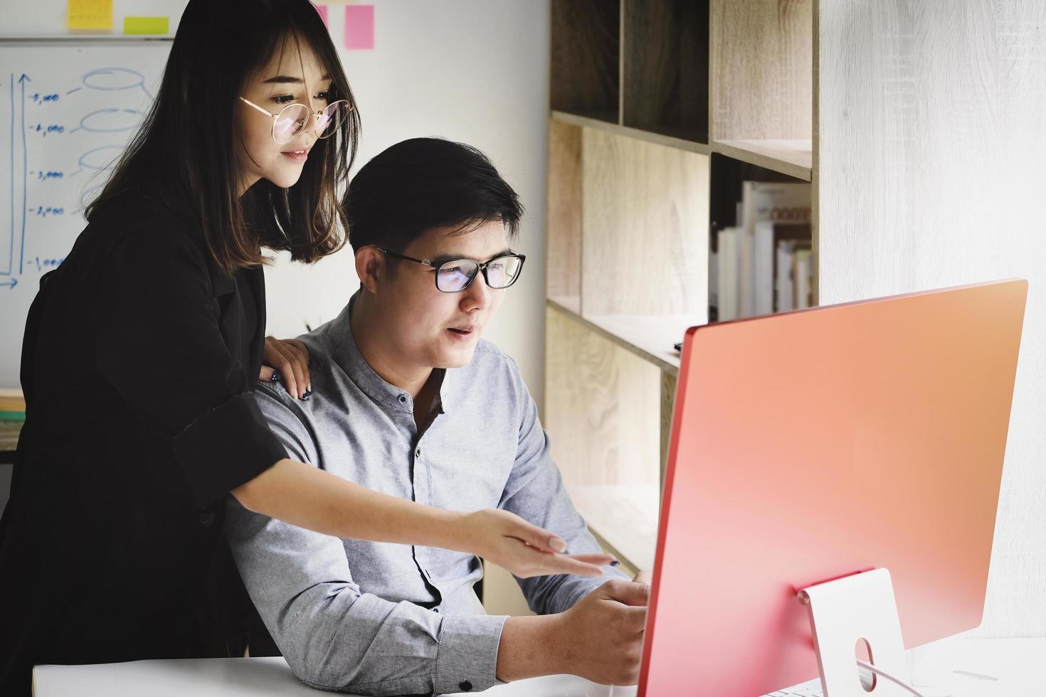 un experto en inversiones apunta a un monitor de computadora para analizar el mercado de valores y enseñarle cómo obtener ganancias. foto