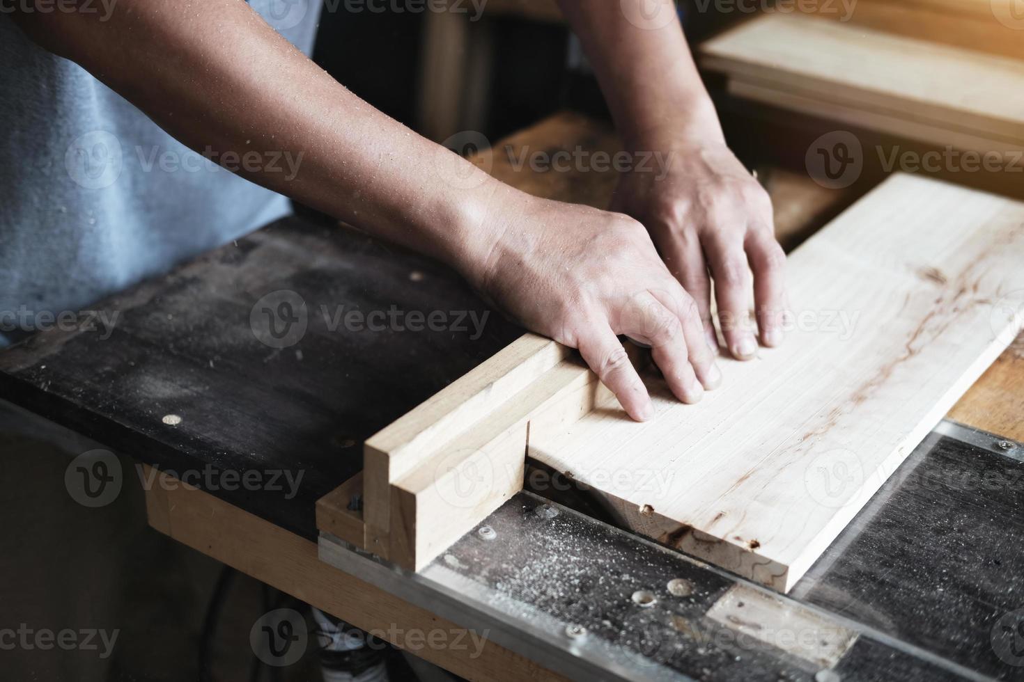 Woodworking practitioners use saw blades to cut wood pieces to assemble and build wooden tables for their clients. photo