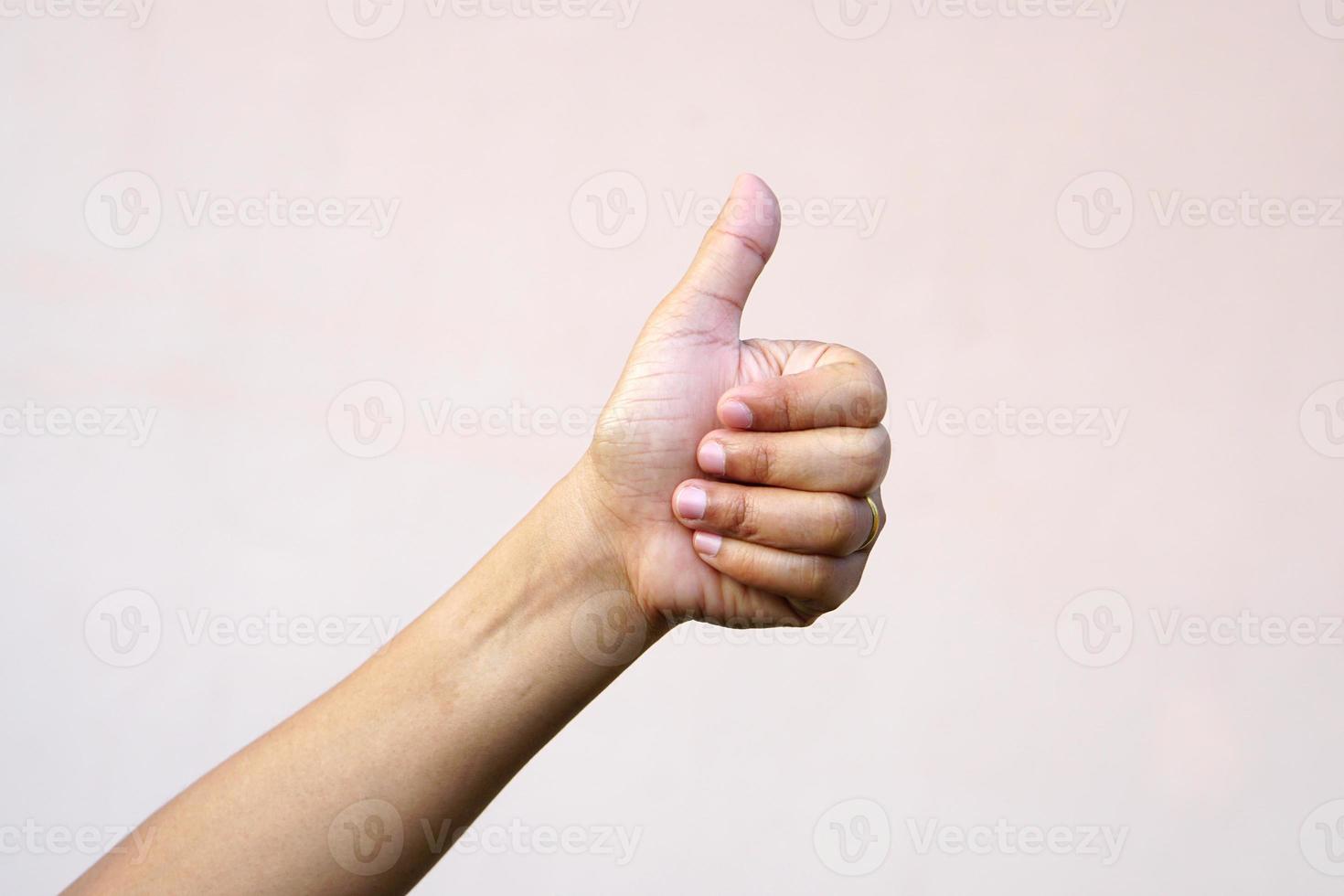 Asian woman's hand raising thumbs as a sign of greatness photo