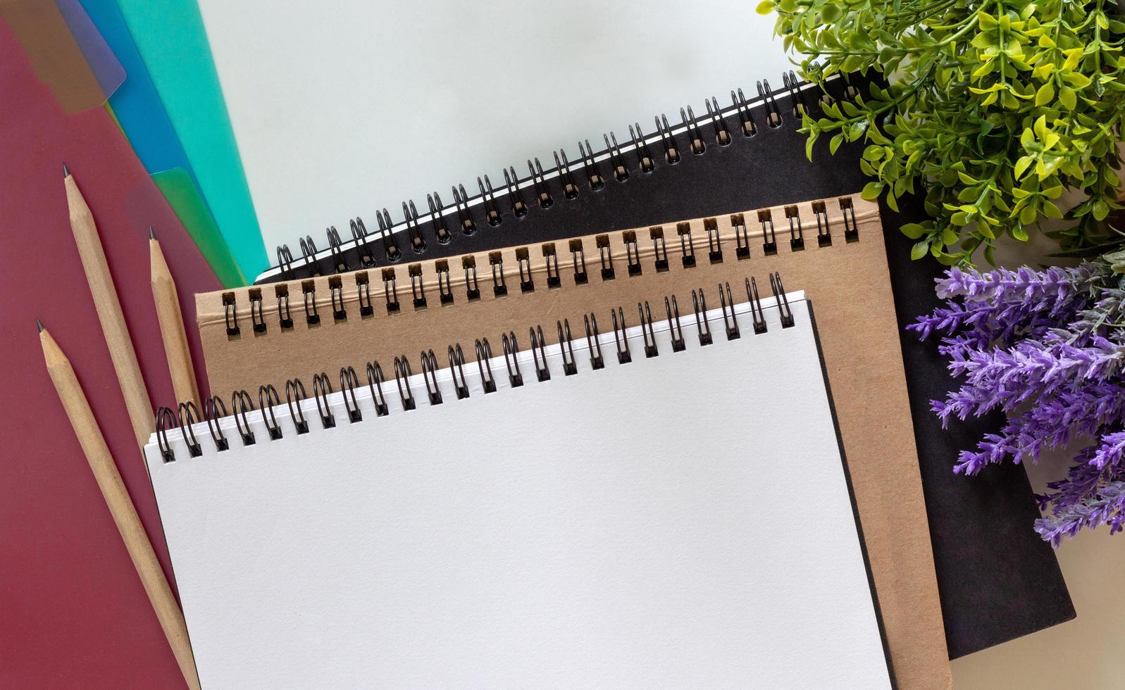 cuaderno de bocetos en blanco, tres lápices de madera e índice de pestañas de colores. foto