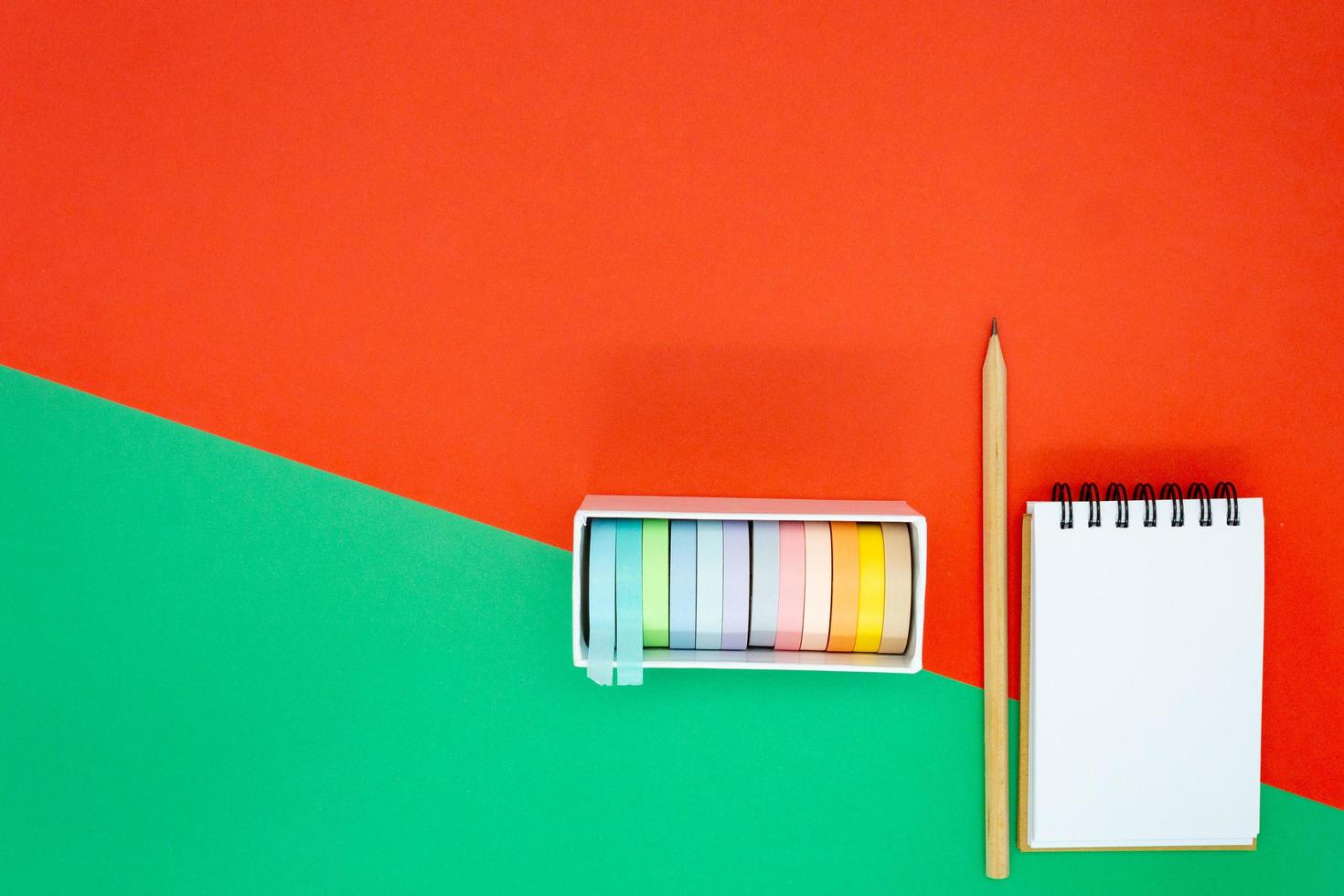 Christmas or holiday concept. White blank mini spiral notepad, wooden pencil and colorful tape. photo