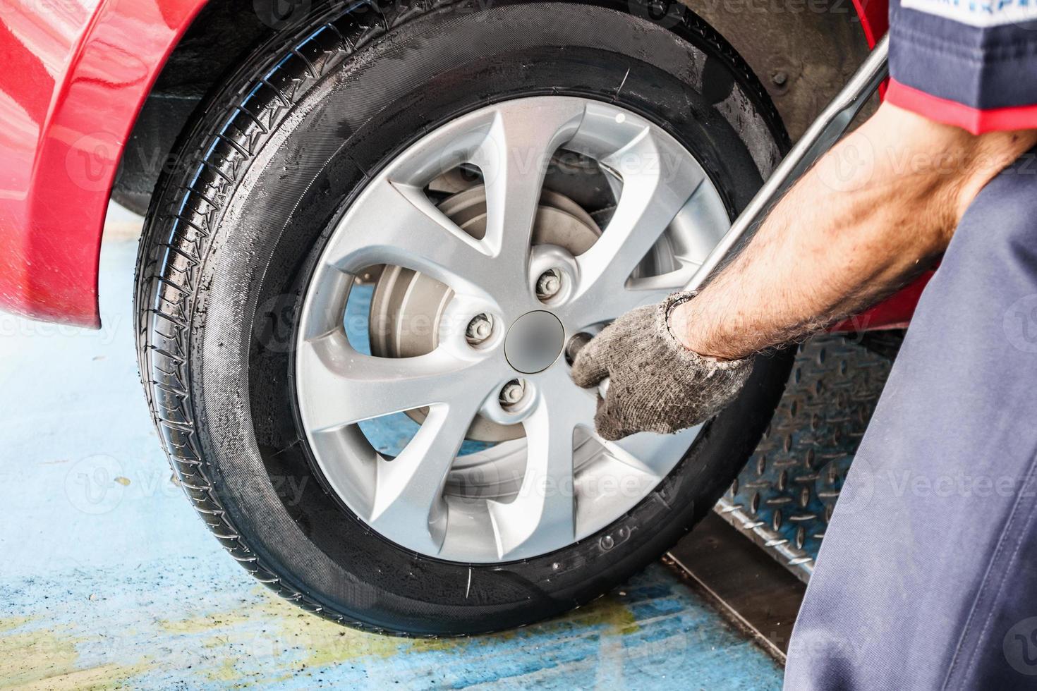 Tire replacement service, Mechanic with wrench working at auto repair shop changing car wheel photo