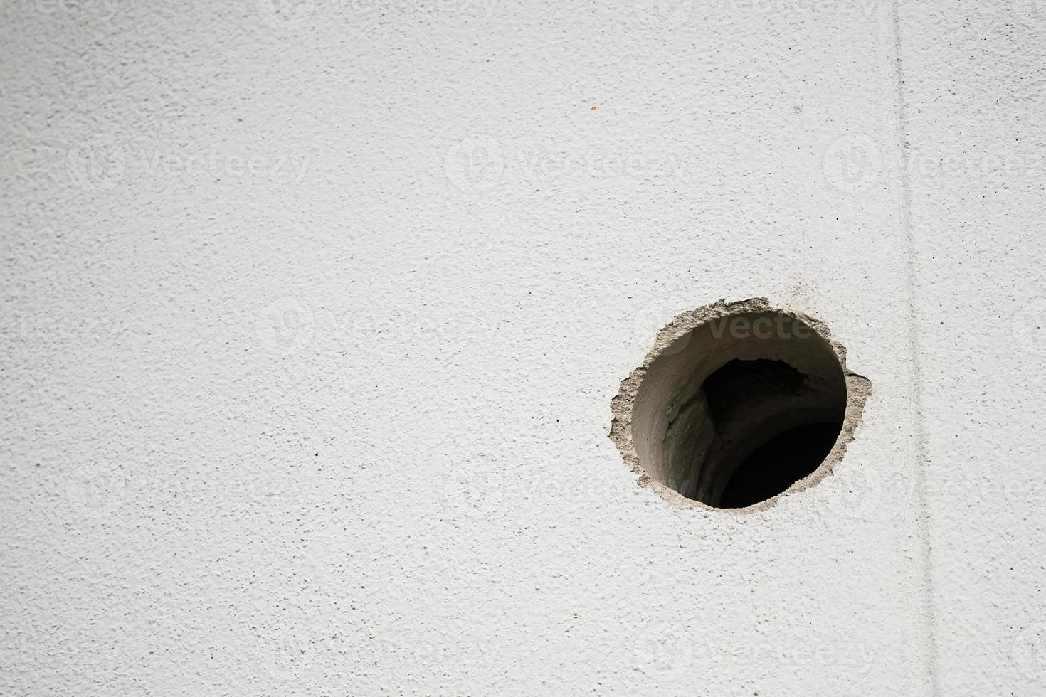 hole in white concrete wall photo