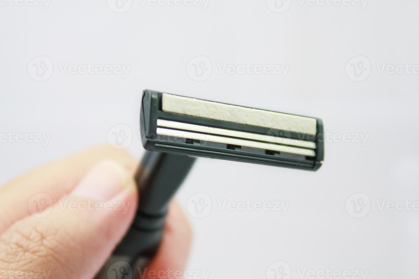 Hand with shaving razor isolated on a white background photo