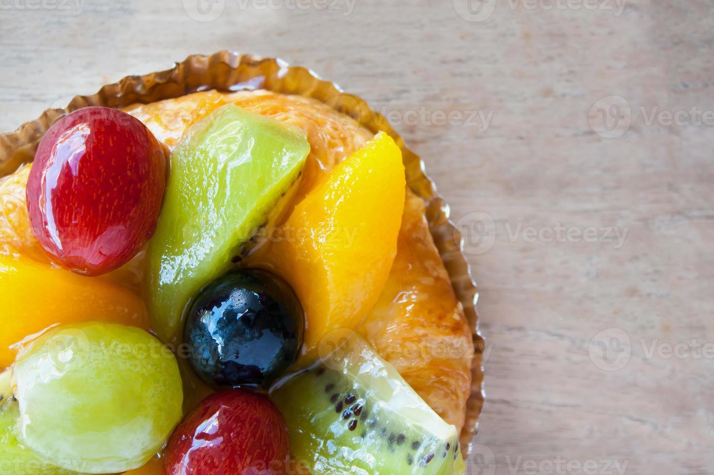 close up danish pastry with fruit on wood table photo