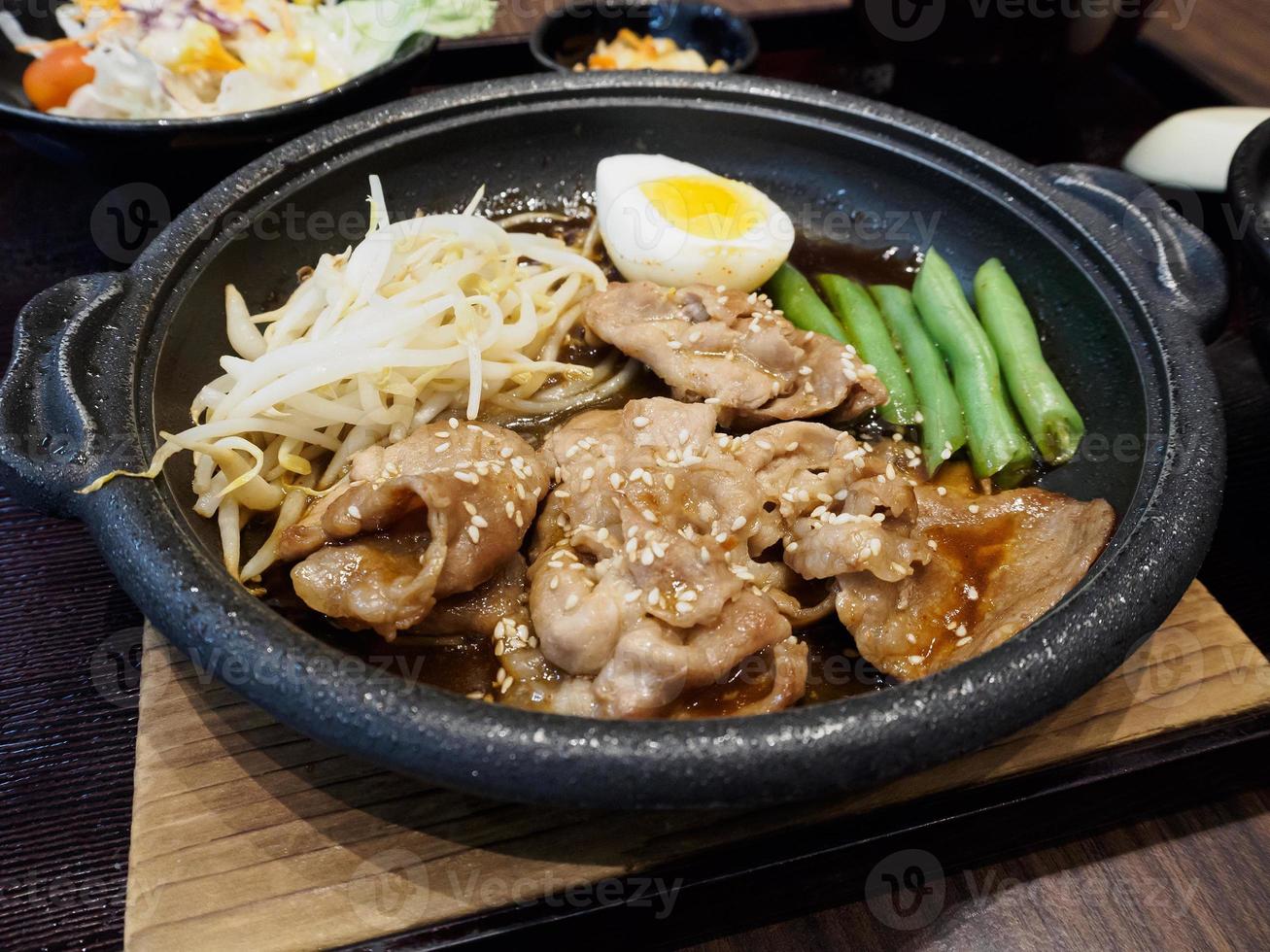 pork teppanyaki with egg and vegetables in hot plate Japanese Cooking