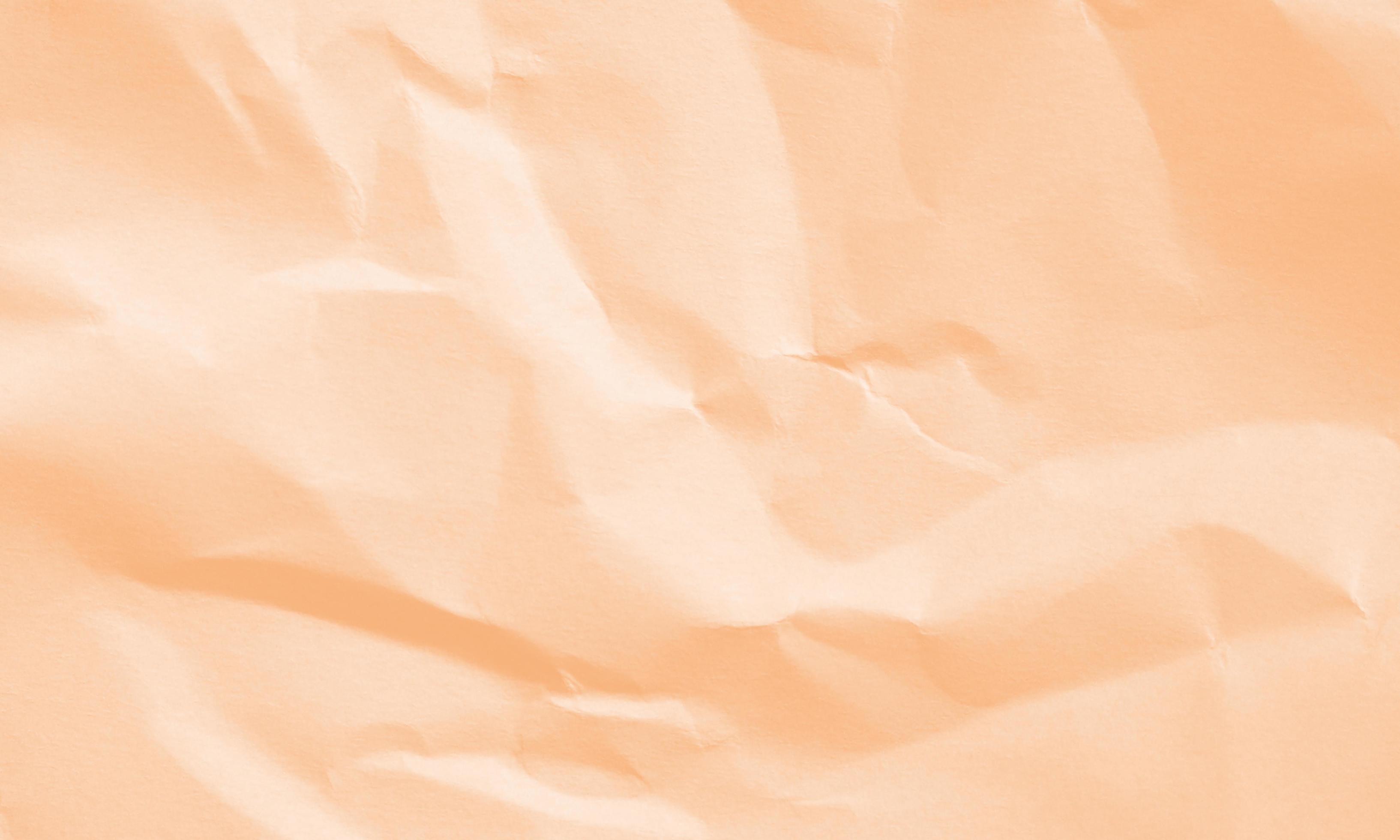 peach colored crumpled paper texture background for design, decorative