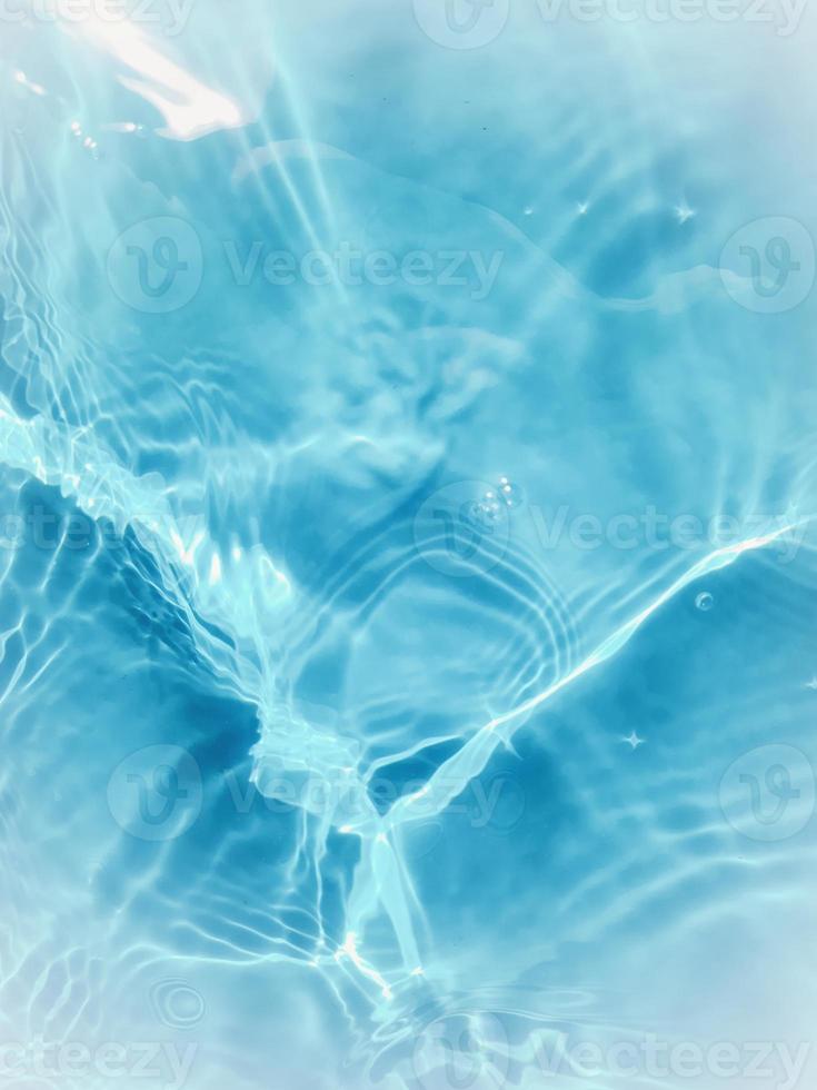 Defocus blurred transparent blue colored clear calm water surface texture with splashes and bubble photo