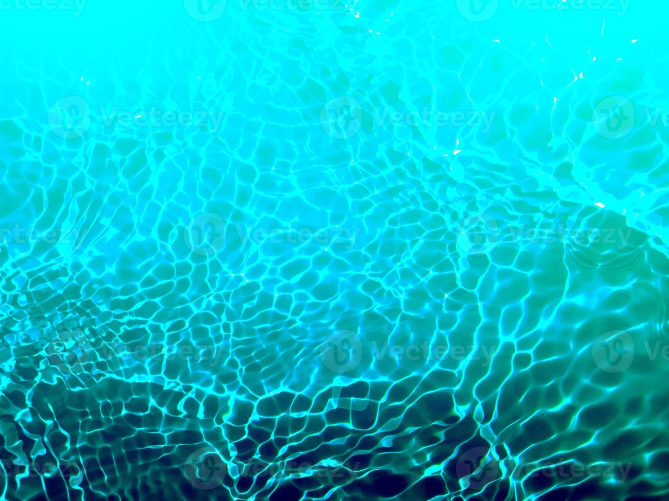 Defocus blurred transparent blue colored clear calm water surface texture with splashes and bubbles. Trendy abstract nature background. Water waves in sunlight. Blue water background. photo