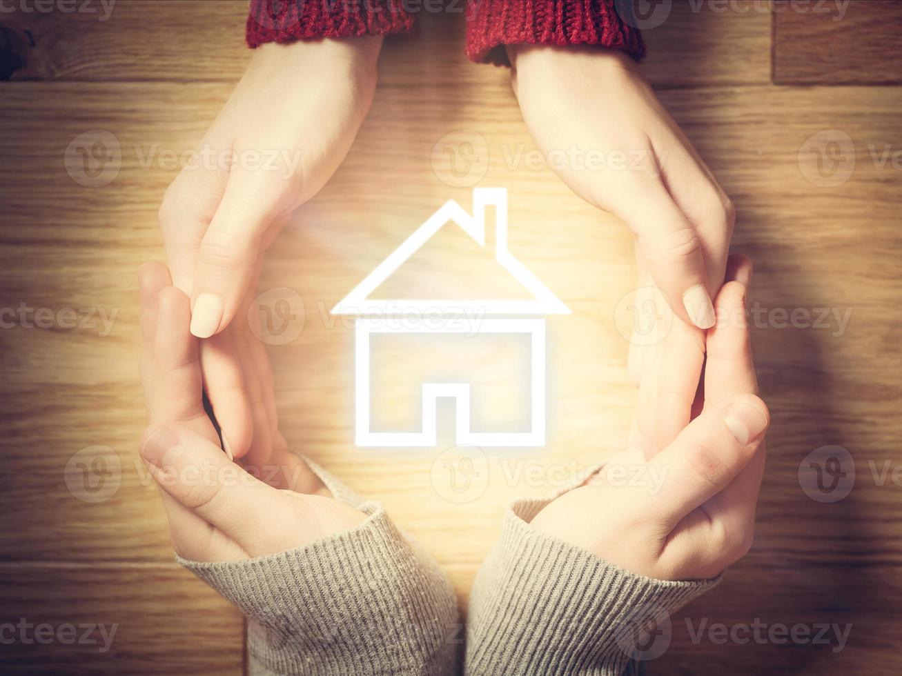 House symbol inside hands circle. Concept of home insurance photo