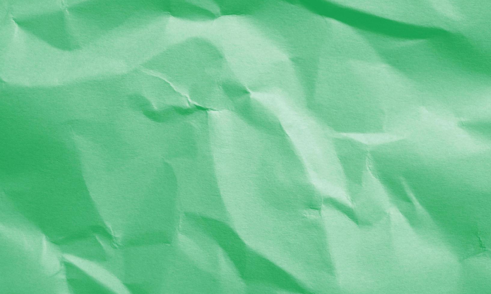 green colored crumpled paper texture background for design, decorative. photo