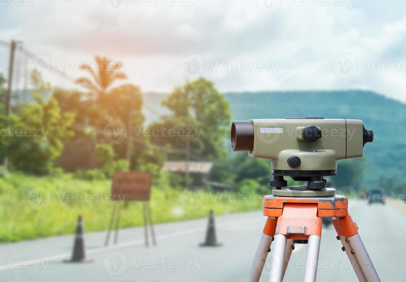 Tacómetro o teodolito del equipo topógrafo con fondo de obra de construcción de carreteras foto