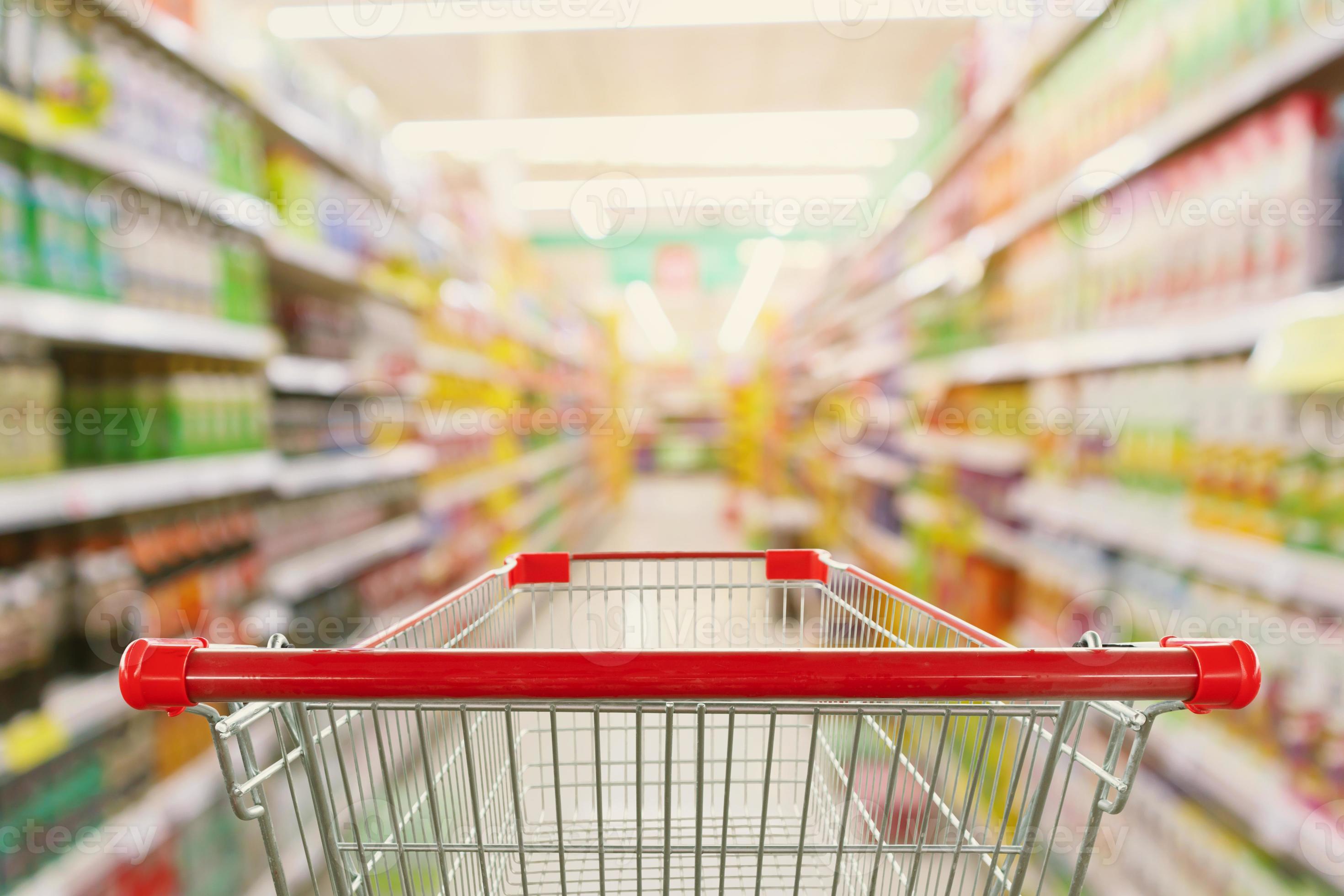 Carro de compras en el fondo del supermercado de desenfoque