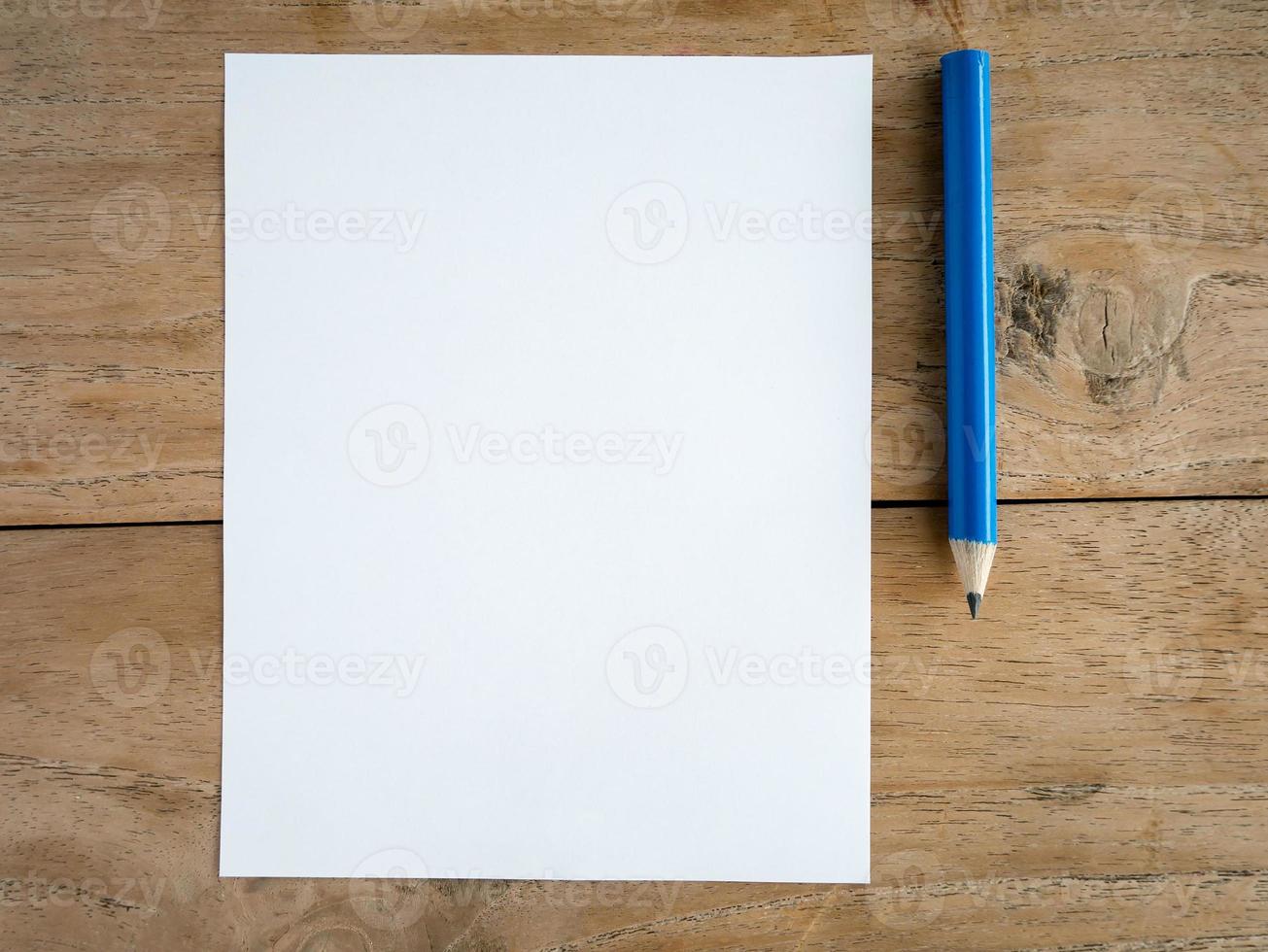 Blank paper with pencil on wood table photo