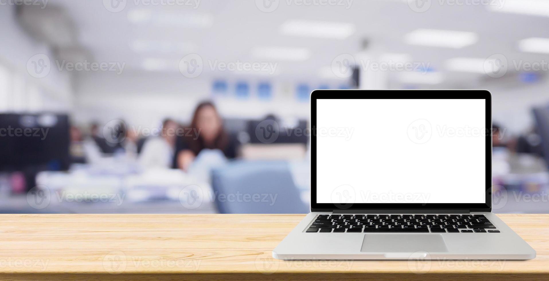 Laptop with blank screen on desk table with blur office interior background photo