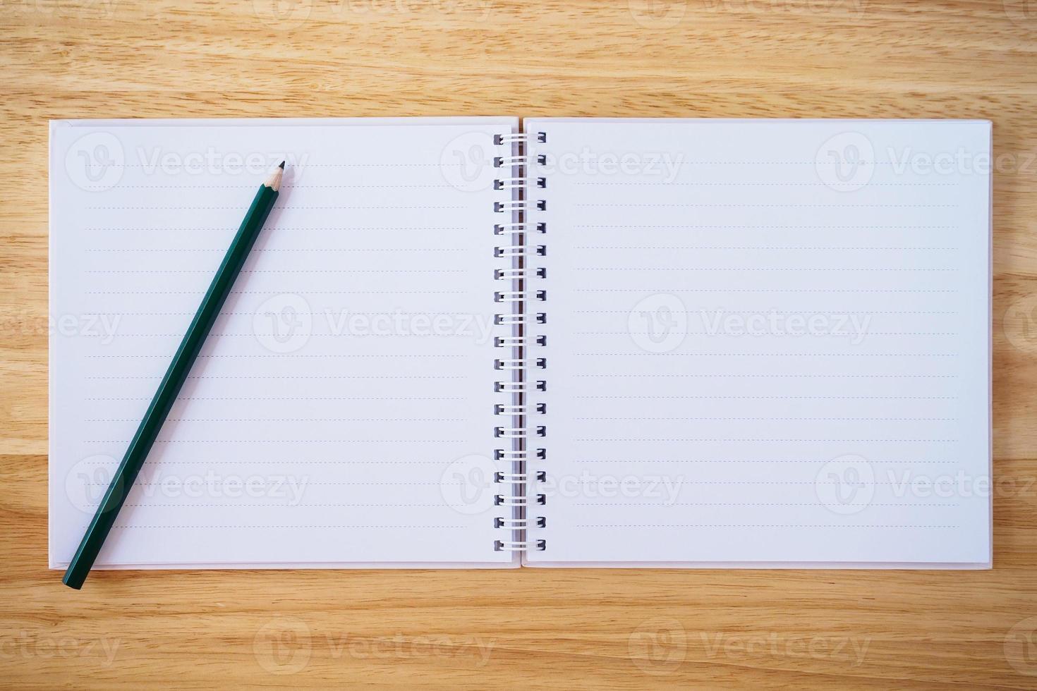 notebook top view with pencil on brown wood desk photo