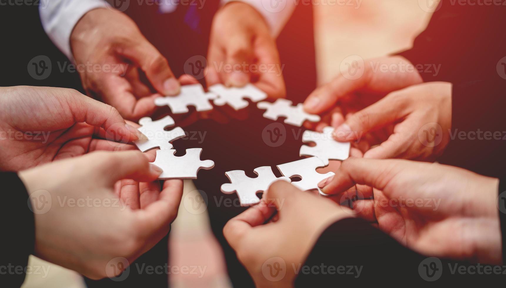 Close-up of a businessman with puzzle pieces in his hands arranged together. teamwork unity in teamwork The concept of combining physical strength and power at work. photo