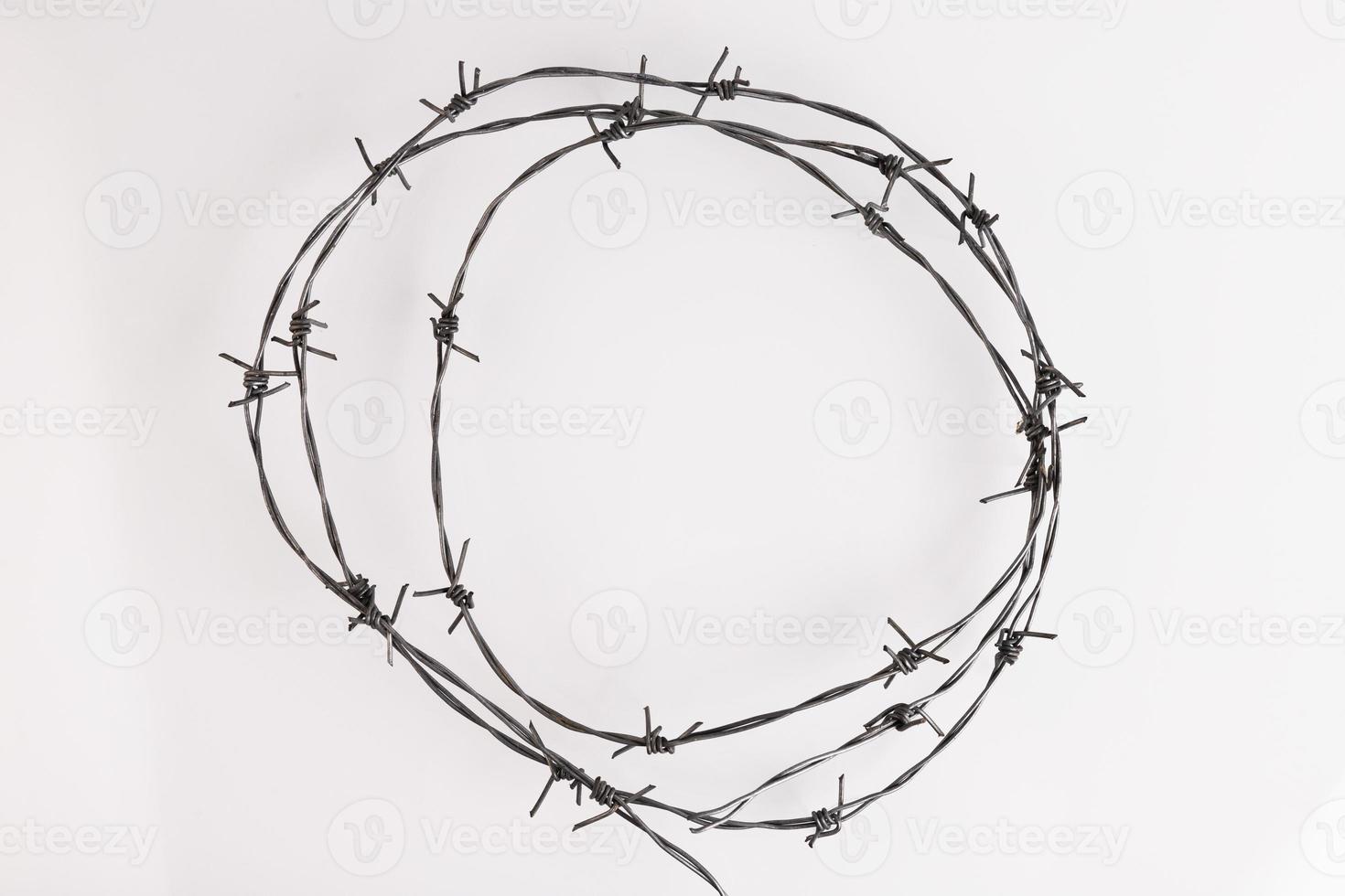 Barbed wire on a white background. Close-up, with sharp spikes arranged in a circle. copy space. photo