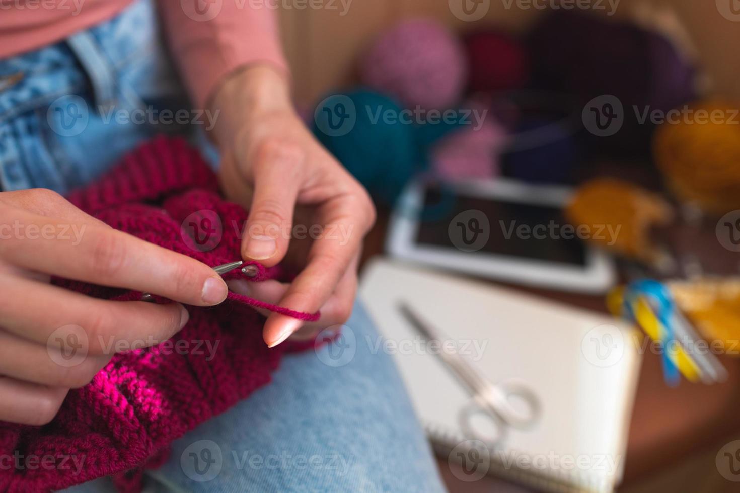 mujer está tejiendo, manos femeninas de cerca foto