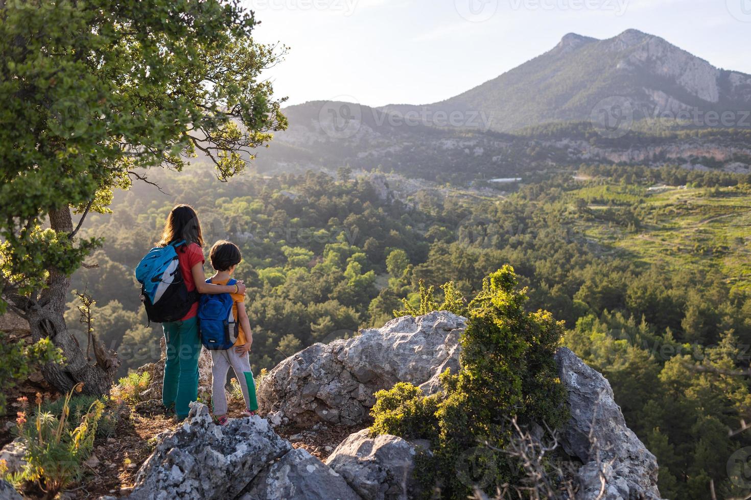 una mujer viaja con un niño, un niño con su madre mirando las montañas foto