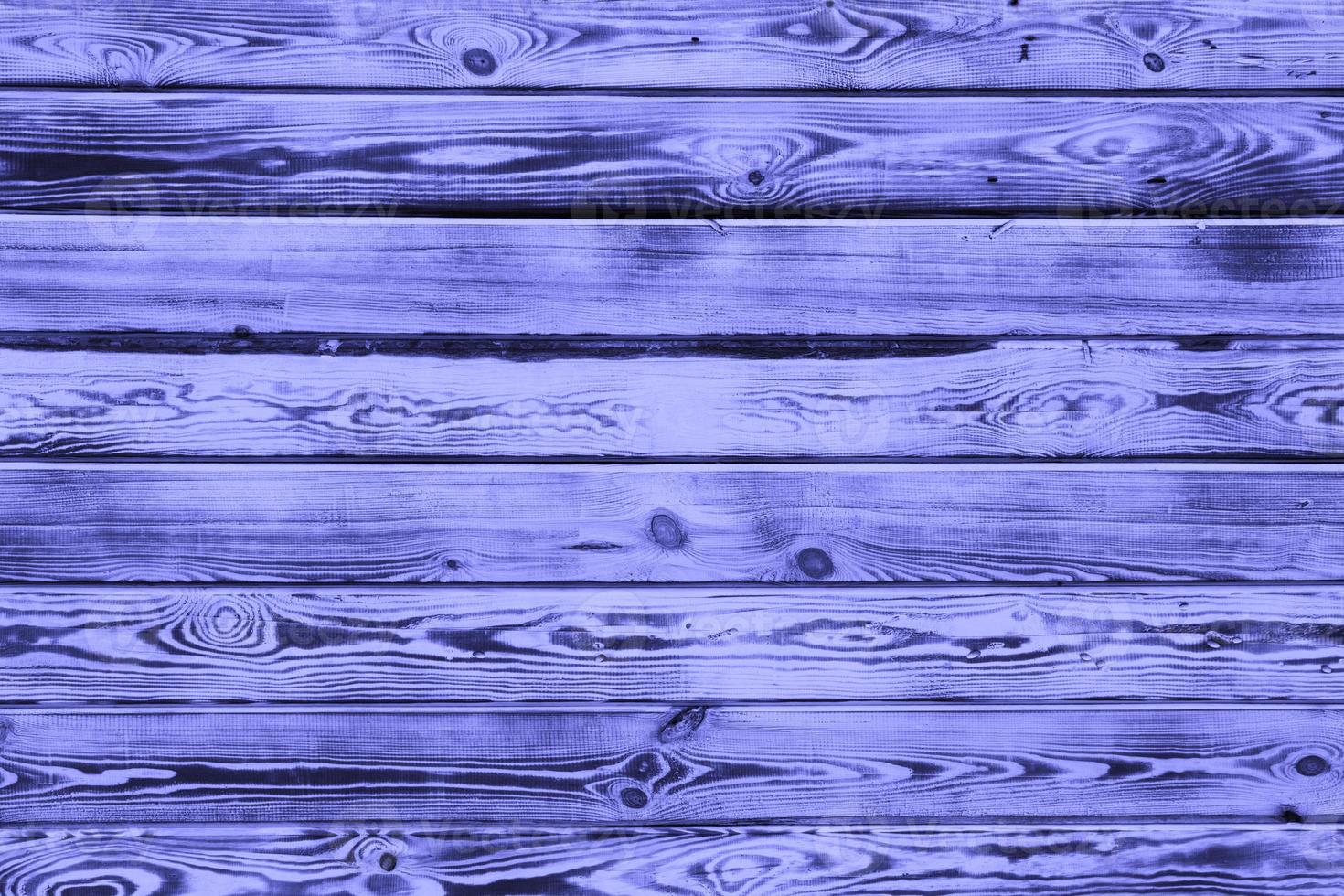 Wooden background. Aging boards by firing and brushing. A beautiful universal natural background made of textured boards in trendy purple color Very Peri. copy space. photo