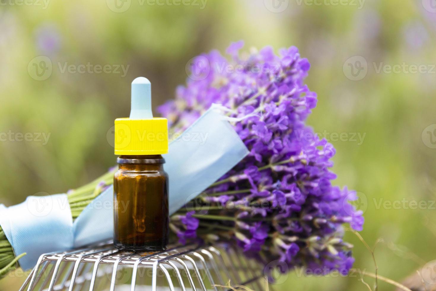 botella de vidrio marrón con cuentagotas de aceite esencial de lavanda con flores de lavanda frescas sobre fondo de campo de lavanda natural. concepto de masaje spa de aromaterapia. lavandula oleum. foto