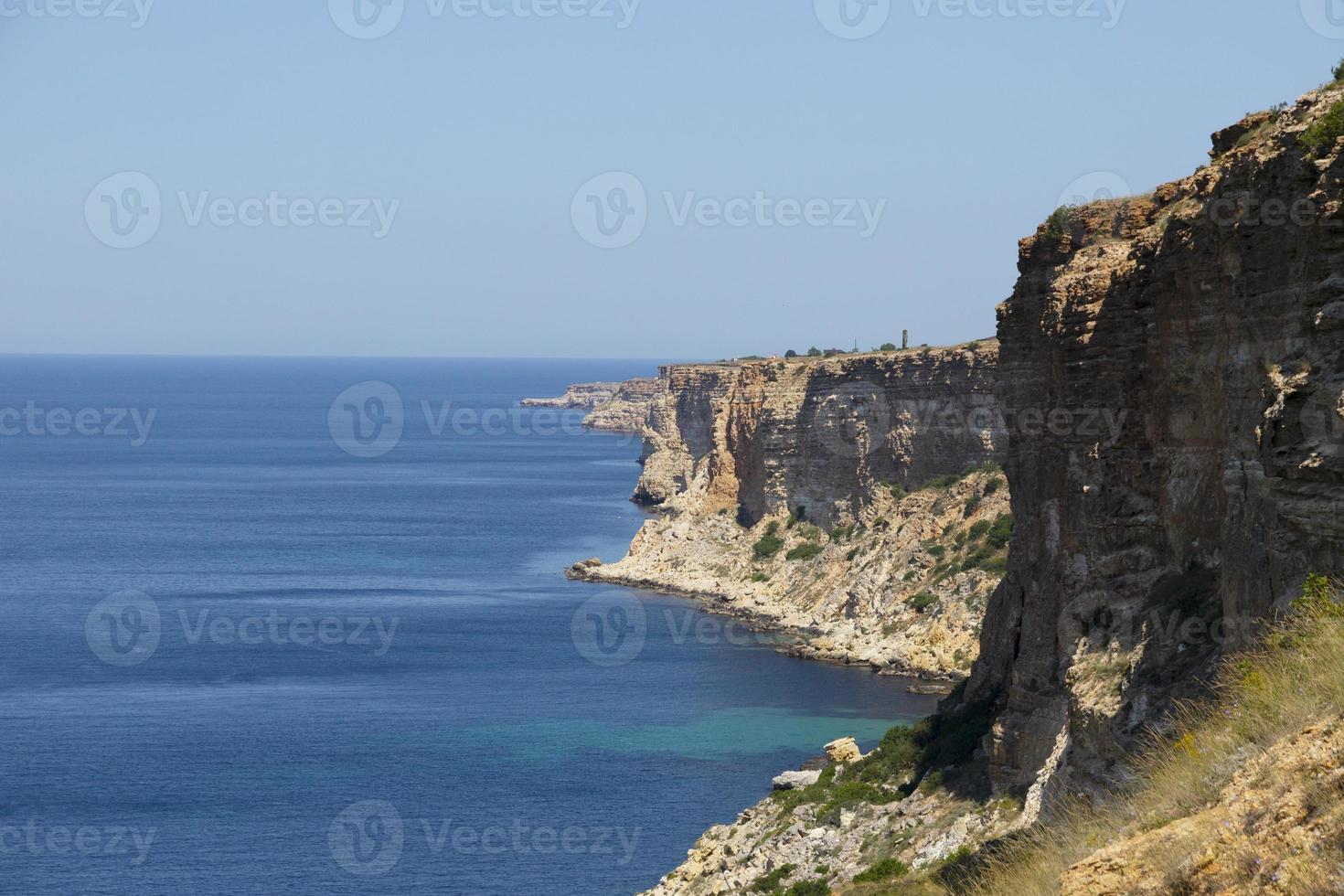 Steep banks, cliffs over the blue sea. The rocks are located on the right. Landscape photo