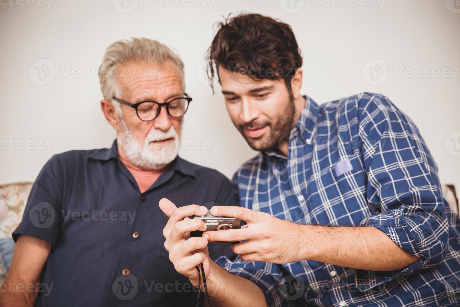 elder family looking photos in digital camera keep in memory happy moment in home.