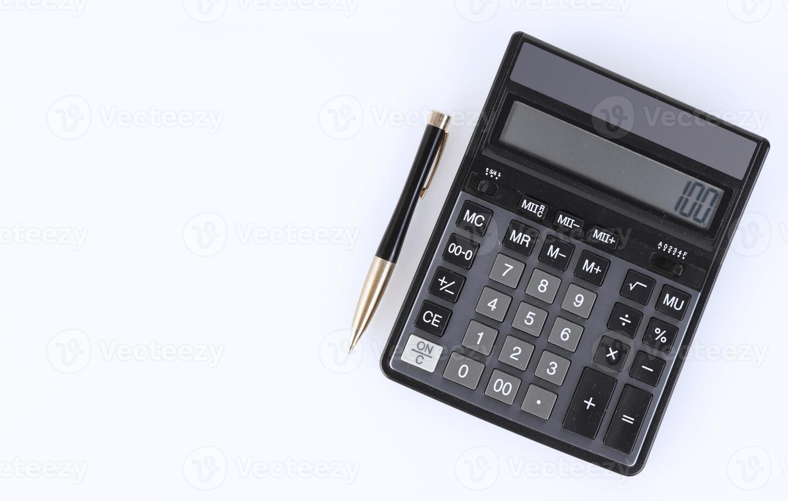Black calculator and yellow-black metal pen on a white background. Financial activity, accounting, tax calculation or savings and investments. View from above. copy space. photo