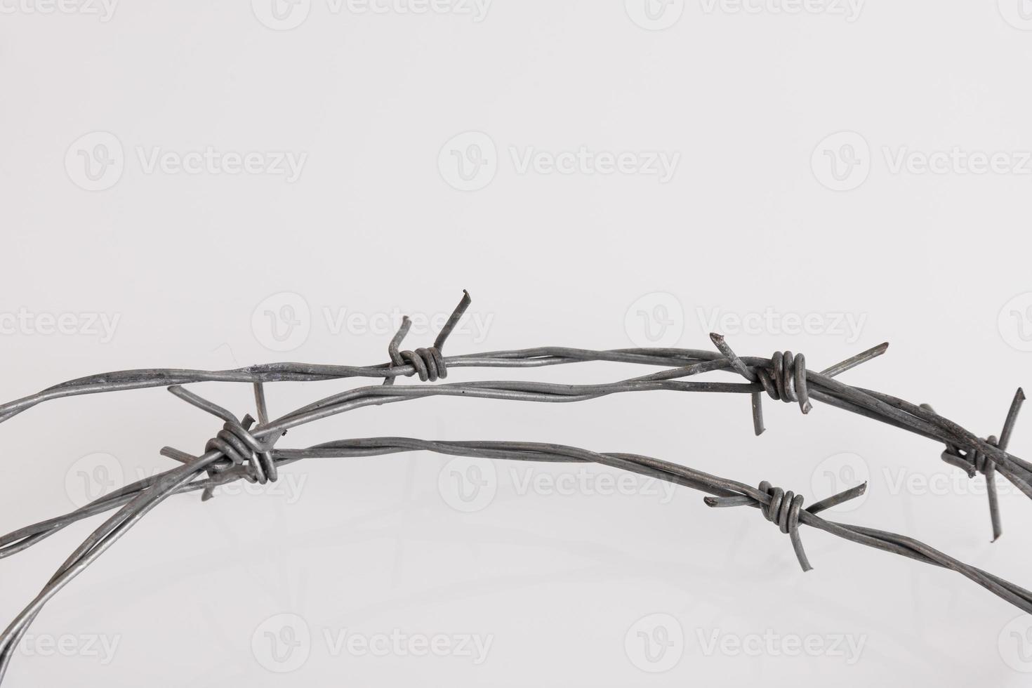 Barbed wire on a white background. Close-up, with sharp spikes arranged in a circle. copy space. photo