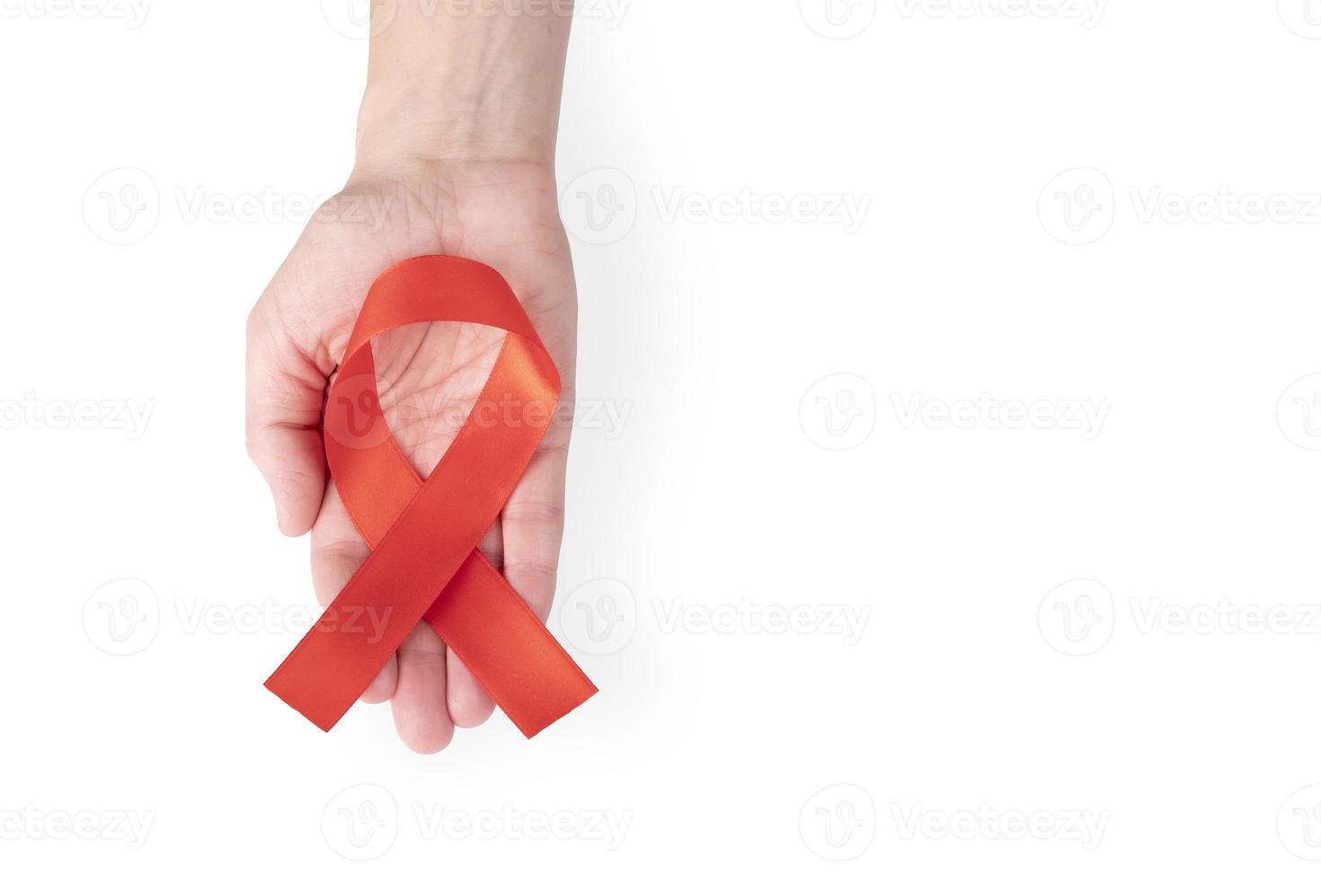 Red satin ribbon on a female palm, isolated on white background. Symbol Awareness about AIDS and blood cancer. copy space. photo