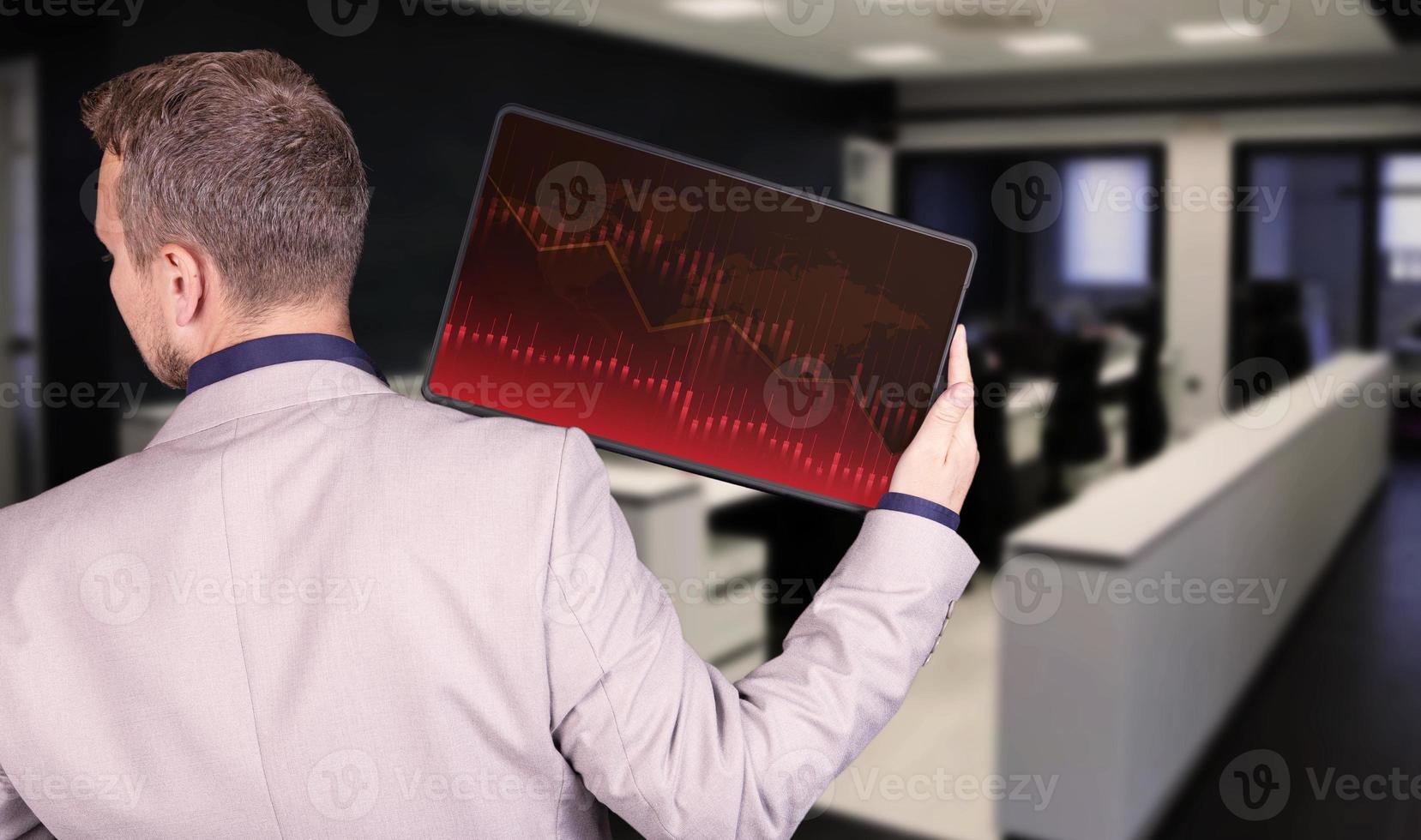 Stock market growth graph, forex manipulation, businessman holding a tablet with a graph of growth and profit on the background of the office. photo