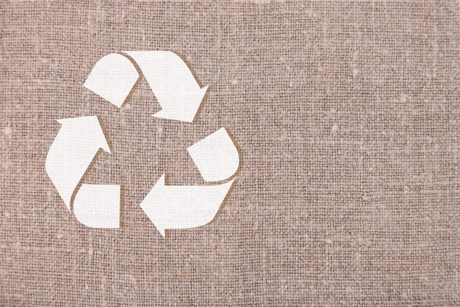 icono de reciclaje blanco sobre lino gris. concepto de reciclaje, producción sin residuos. copie el espacio foto