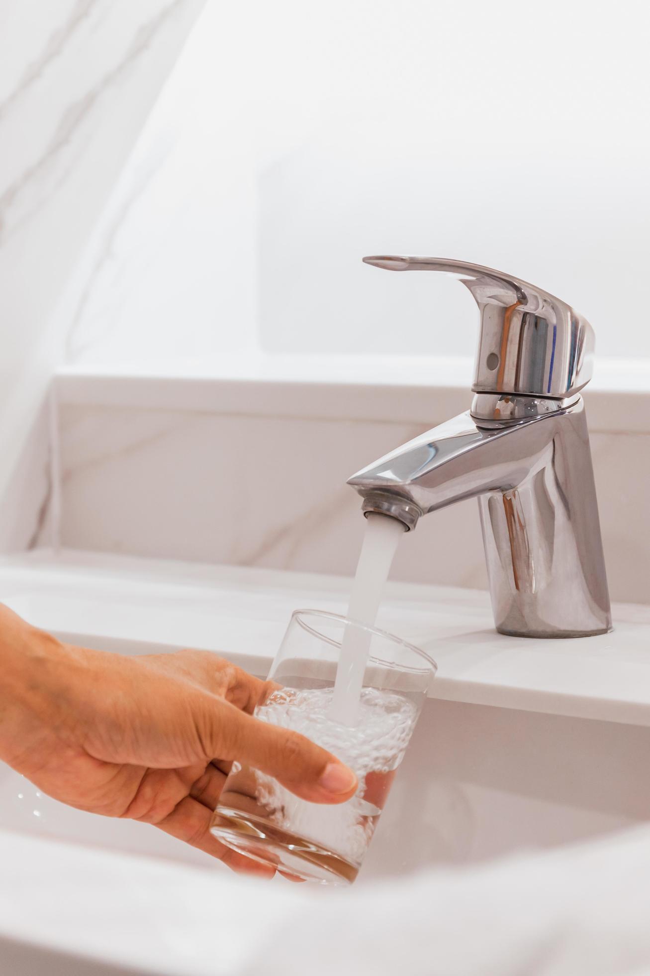 Man filling glass of water at sink in bathroom. 8137199 Stock Photo at