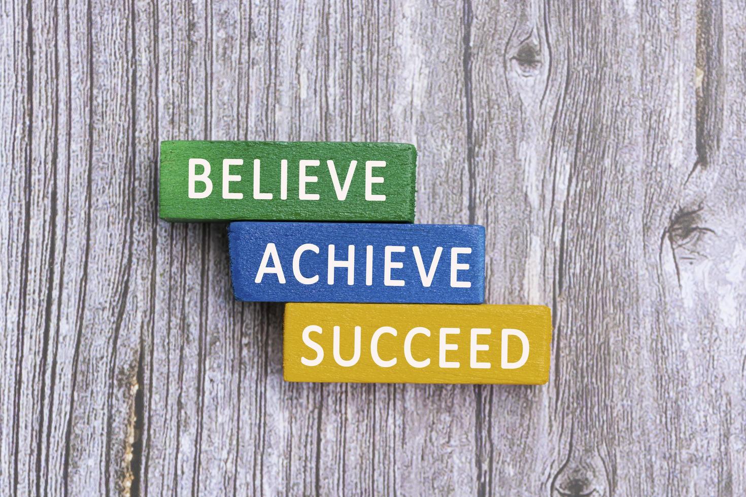 Motivational quotes on wooden block cube - Believe, achieve, succeed. photo