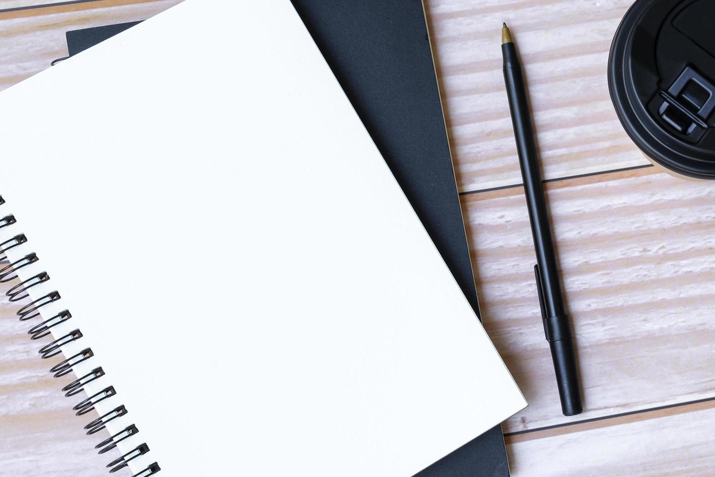 Notepad, pen, disposable and coffee cup on wooden table. Copy space. Flat lay. photo