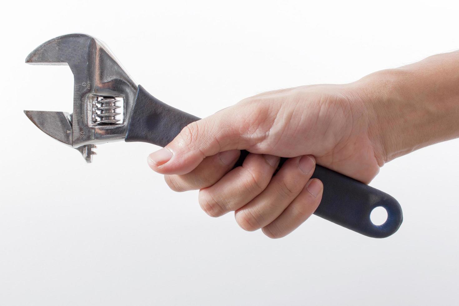 male hand holding an adjustable wrench on white background photo