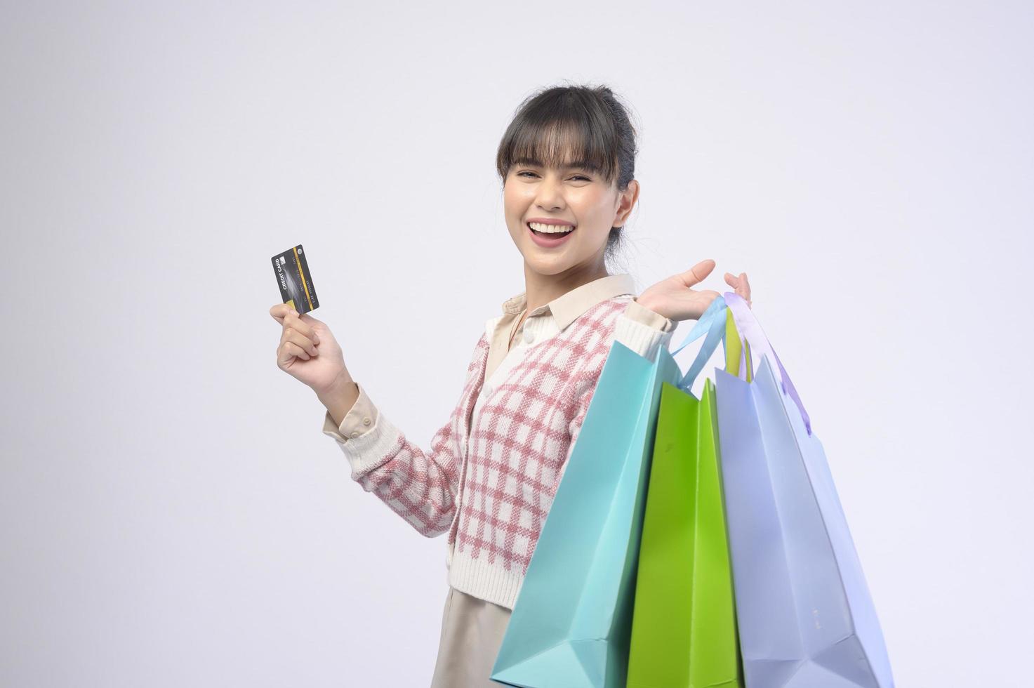 Shopper atractiva mujer sosteniendo bolsas de compras sobre fondo blanco. foto