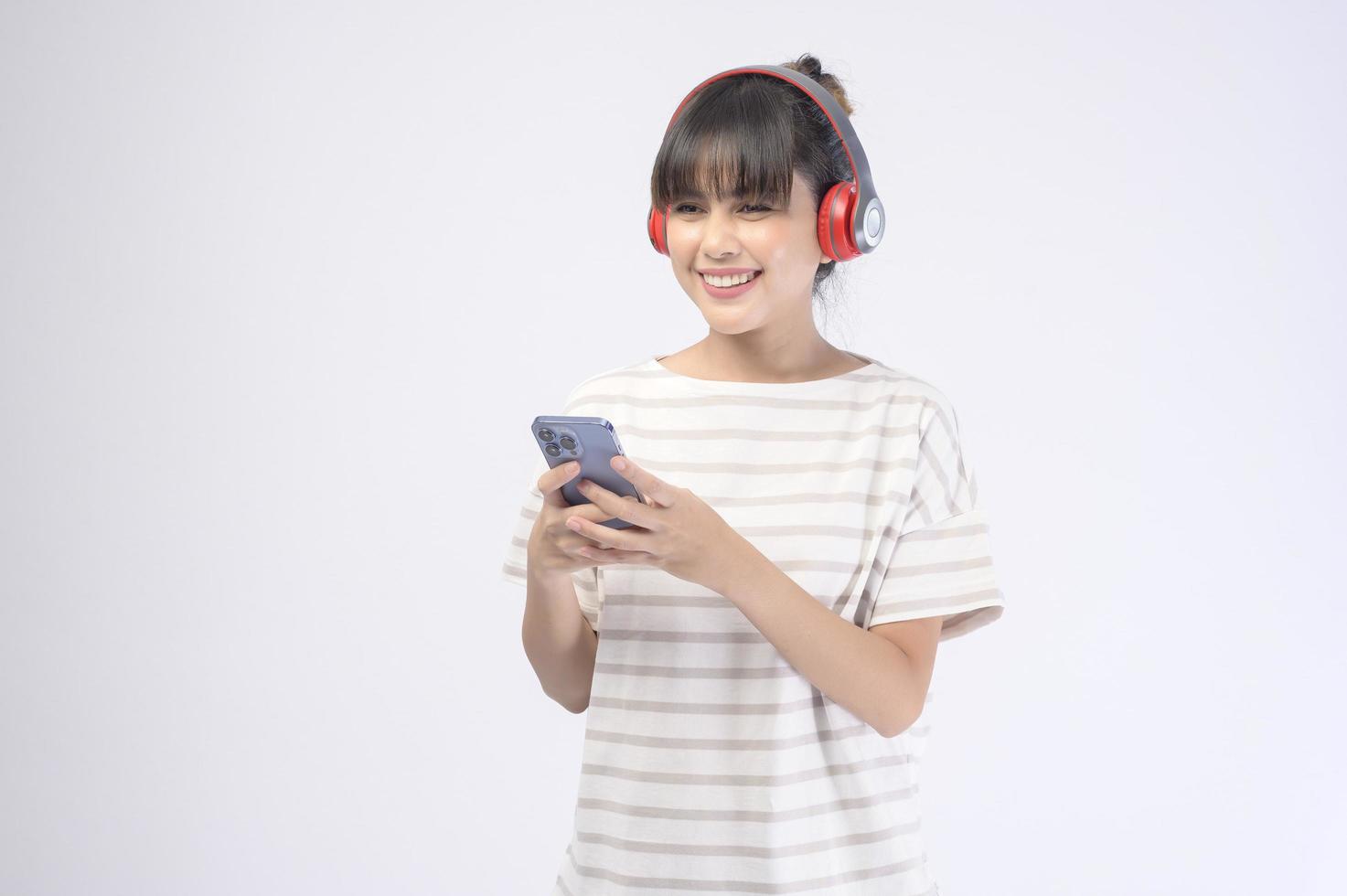 Hermosa mujer joven con auriculares sobre fondo blanco. foto