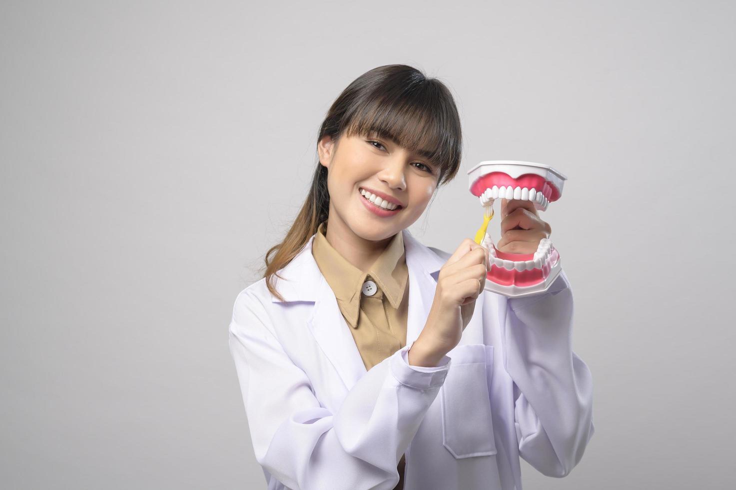 Young female dentist smiling over white background studio photo