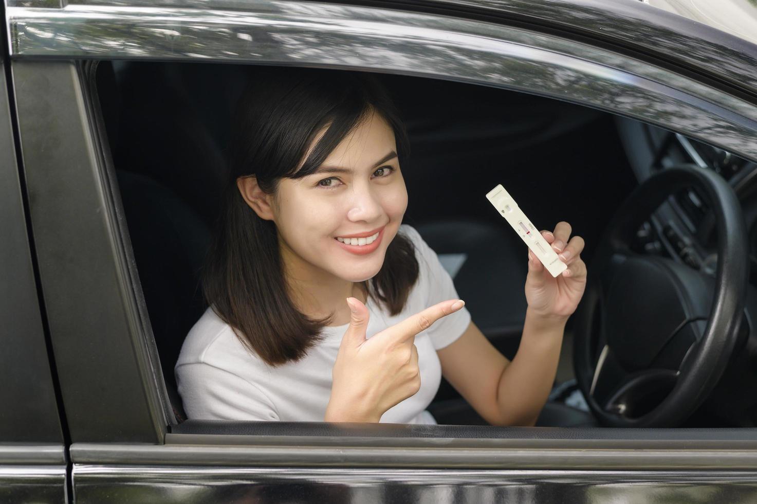 A woman holding atk in car, do a self-collection test for a COVID-19 test, health and safety photo