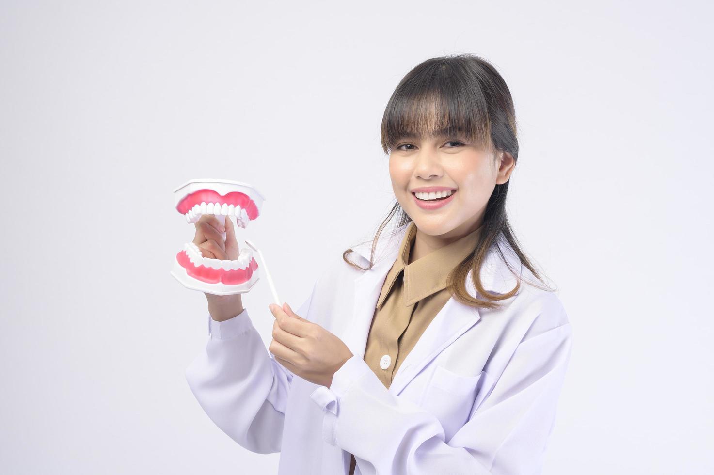 Young female dentist smiling over white background studio photo