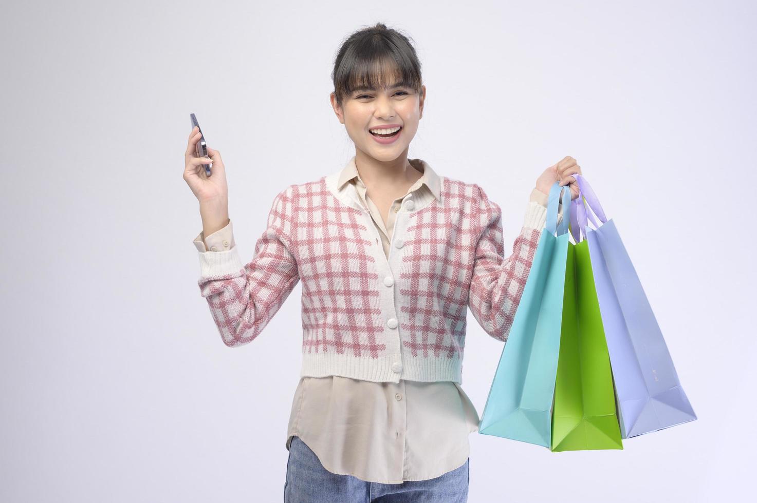 Attractive shopper woman holding shopping bags over white background photo